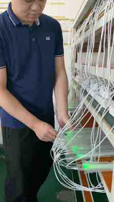 TUODI employee checking connected light units on a rack