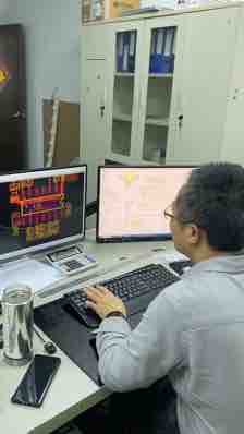 TUODI employee working at a dual-monitor electronics engineering workstation